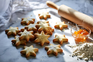 Festive Star Shaped Cookies Sprinkled with Powdered Sugar Accompanied by Homemade Fruit Preserve and Rolling Pin Baking Preparation Still Life