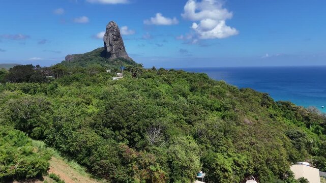 Imagem a&eacute;rea do Morro do Pico em Fernando de Noronha, marco natural cercado por praias tropicais, &aacute;guas cristalinas e vegeta&ccedil;&atilde;o nativa, cart&atilde;o-postal do arquip&eacute;lago