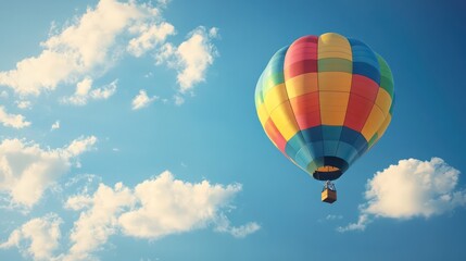 Naklejka premium Colorful Hot Air Balloon Ascending Through a Sky Filled with Puffy White Clouds