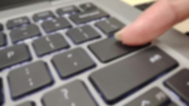 Person Finger Pressing Enter Key on Modern Laptop Backlit Keyboard Close Up Work Action View