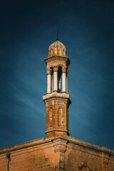 Fototapeta premium Ancient Architectural Marvel A Captivating View of an Old Building's Tower Against a Blue Sky