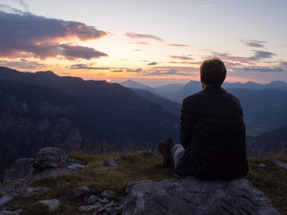 Grenairon, France - September 2nd 2024: A hiker enjoying the view over the valleys and mountains during sunset