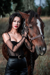 Fototapeta premium Young beautiful sexy woman is walking with a horse in nature. Freedom. Peace of mind. Portrait.