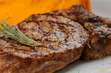 Grilled pork loin on a white plate macro photo