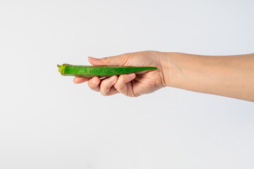 Fresh okra and hand isolated on white background