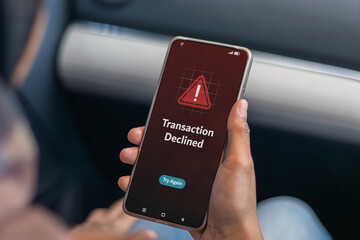 Payment failed or declined concept. A woman holding smartphone with declined transaction notification on screen.