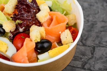 salad fresh vegetables with salmon in disposable dishes macro photo