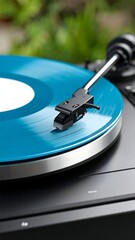 Close-up of a turntable playing a vibrant teal vinyl record