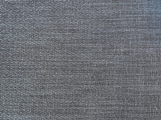 Close up of dark brown polyester fabric, seamless background texture.