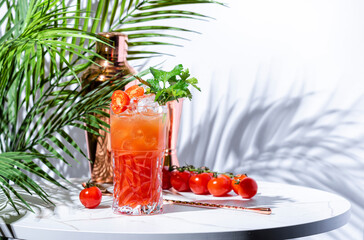 Tomato spritz alcoholic cocktail drink with gin, dry vermouth, tomato water, club soda, prosecco, cherry tomatoes and parsley with copper bar tools