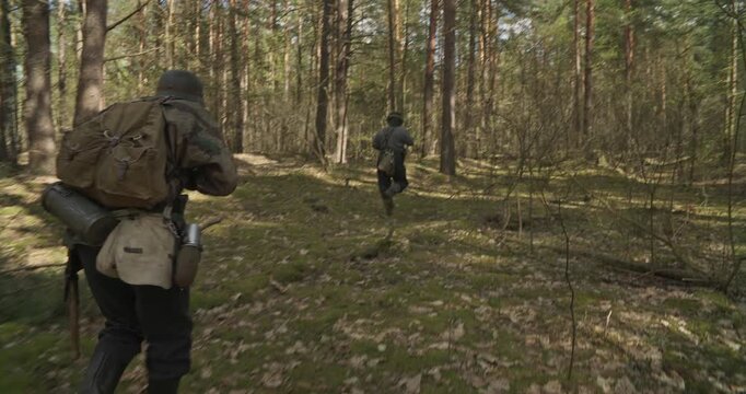 Group Of Soldiers With Carabines Mauser 98k Sneaking Through Forest. Wermacht Military Uniform. Reenactors Dressed As German Infantry Soldiers Make War Ambush In Forest. Soldier Aiming From Rifle