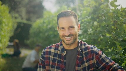 Winemaker smiling in vineyard during grape harvest