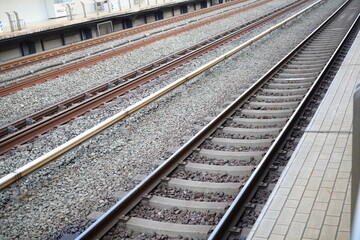 Fototapeta premium Parallel Railway Tracks Extending into the Distance from Shizuoka Hamamatsu Station Platform