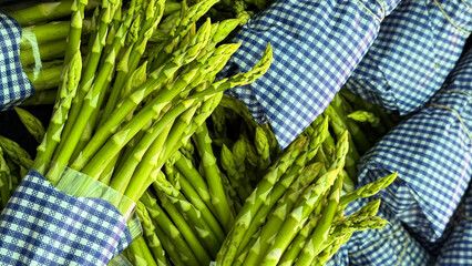 Vibrant asparagus bundles cloaked in gingham, whispering tales of spring equinox feasts and rustic...