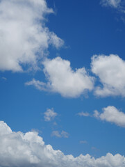 Obraz premium A bright blue sky with scattered white clouds on a clear day. The simple composition and vivid colors make it ideal for backgrounds, weather themes, or calming natural visuals.