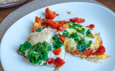 Delicious fried eggs with vegetables and herbs creating a healthy and colorful breakfast