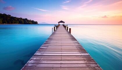 Fototapeta premium Wooden Pier Over Crystal Sea at Sunset with Tropical Paradise.