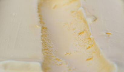 Close-up macro shot of creamy vanilla ice cream with visible scoop marks smooth and rich texture, Ideal for food backgrounds.