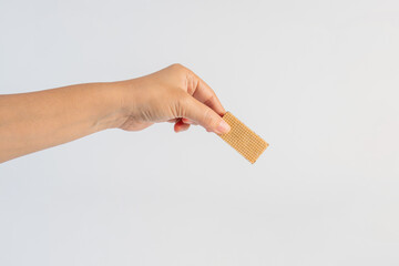 Wafer biscuit with chocolate cream and hand isolated on white background