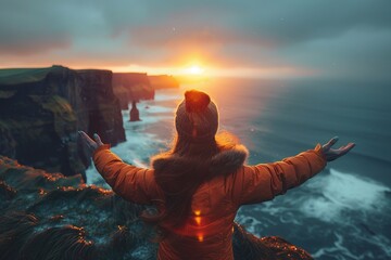 Tourist enjoying breathtaking sunset over cliffs of moher, county clare, ireland
