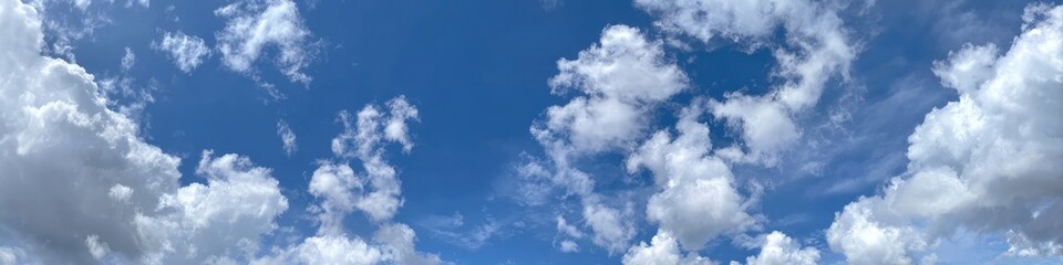 Fototapeta premium Whimsical clouds against a vibrant blue sky