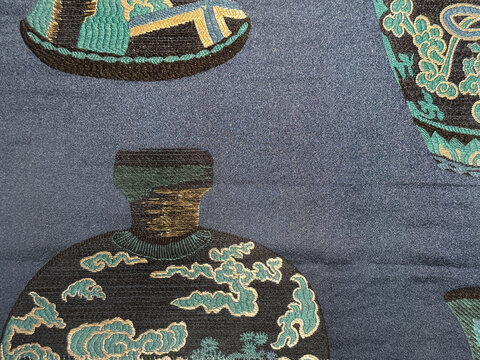 Close up illustration of vintage old Chinese jar with clouds pattern sewn on a silky blue fabric background. Suitable for wallpaper, upholstery, and other graphics. Seamless background texture.