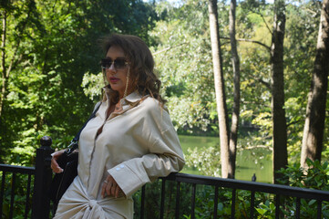 Naklejka premium Portrait of a cute young brunette Caucasian woman in a city park.