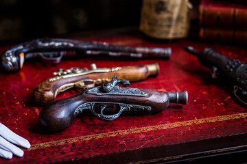 A red table with a few guns on it