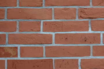 Brick wall with earthy tones showcasing a textured surface and subtle imperfections in a well-lit interior space