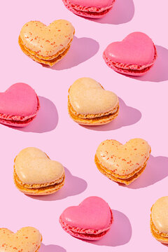 Heart shaped macaron dessert pattern on pink background