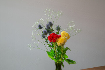 白い部屋に置かれたケイトウとエリンジウムとカスミソウ