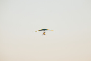 A motorized hang glider in flight, suspended in the sky. A minimalist image conveying freedom, adventure, and extreme sports. The concept of free flight, exploration, and aerial tourism.