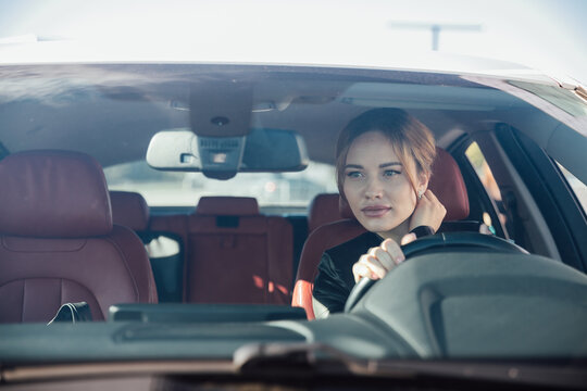 Woman Driving A Car On The Road Looking In The Mirror - Powered by Adobe