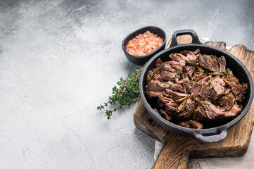 Slow cooked Shredded beef ragu in a skillet. grey background. top view