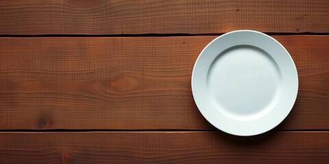 Clean white plate on rustic wooden surface, overhead view, photography, brown
