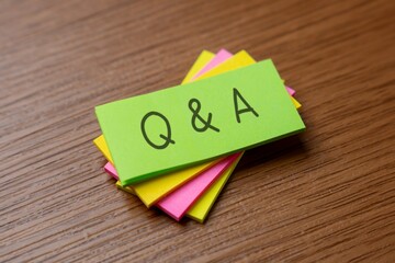 A stack of colorful sticky notes with handwritten letters "Q and A". Communication, problem-solving, and information exchange concept.