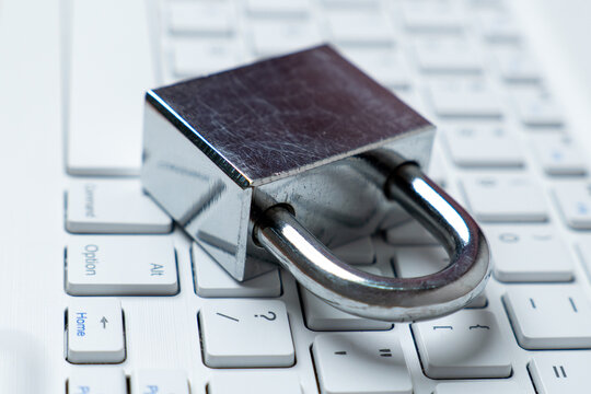 Silver padlock on a white keyboard. Digital security, data protection, and online safety concept. - Powered by Adobe