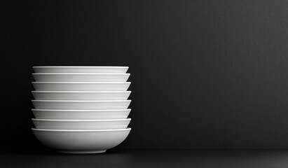 Stacked white bowls against a sleek black background, side-view composition with centered focus and clean negative space for text or design