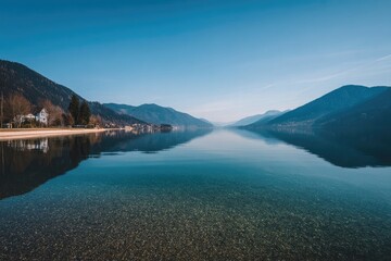 Tranquil lake reflecting mountains under a clear sky