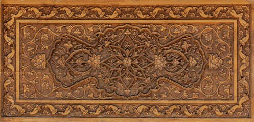 Traditional Uzbek wood carving with intricate floral and geometric patterns in oriental design