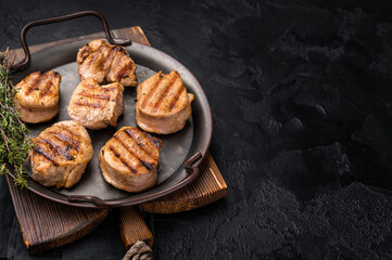 Flavorful grilled pork tenderloin cutlets, expertly cooked to perfection, promising a delicious dining experience. black background. top view