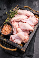 Beautifully arranged raw chicken wings, ready to soak up your favorite marinades for a tasty culinary adventure. black background. top view