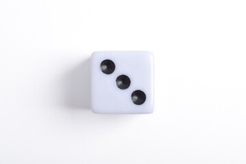 One white dice isolated on white background, top view