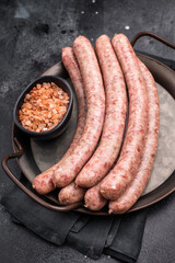 Close up of uncooked raw sausage showcasing its juicy texture, ideal for flavorful dishes and culinary creativity. black background. top view