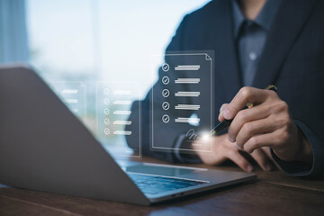 Digital document checklist concept with businessman using laptop to review tasks, approve items, and sign forms, representing paperless workflow and online business management. signature e document