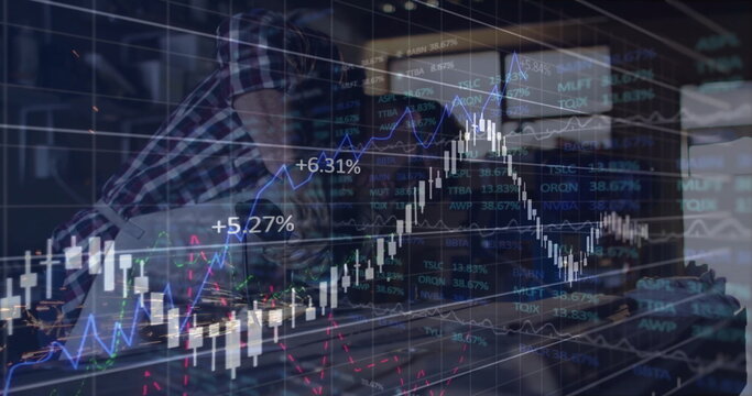 Leaning analyst examining market data on monitor and laptop at office desk, with translucent charts