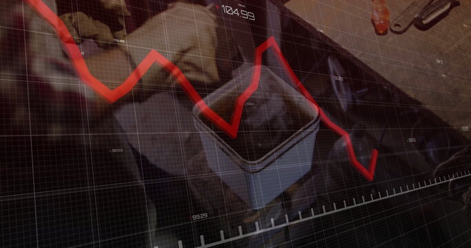 Gloved technician handling open container on workshop bench, displaying red line graph