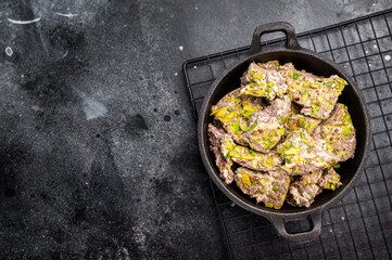 Oriental Halva with pistachio in a skillet. Natural vegan sweets. black background. top view.