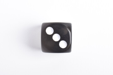 One black dice isolated on white background, top view