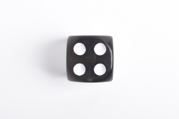 One black dice isolated on white background, top view
